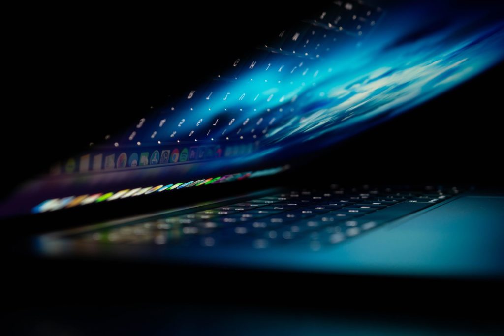 Ein halb zugeklappter Laptop spiegelt die Tastatur im Bildschirm