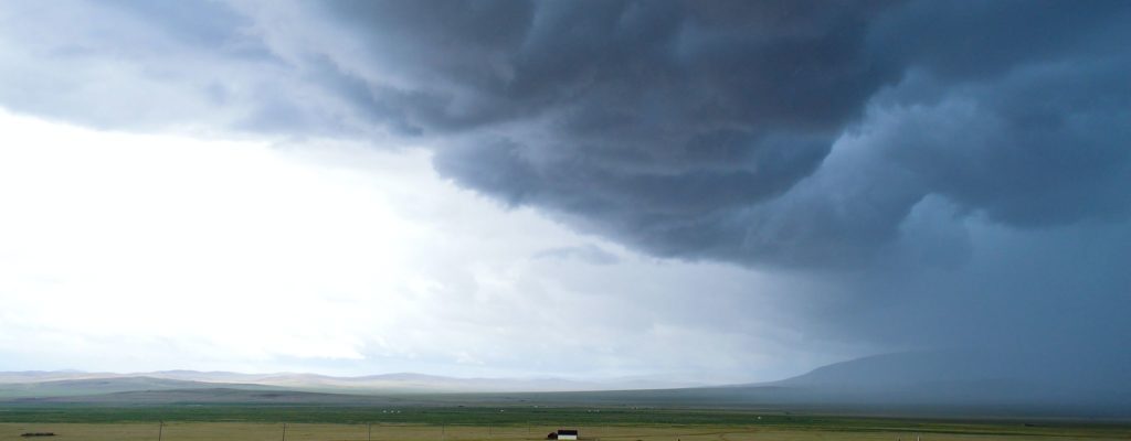 Sturm Wolken über Wiesen und Bergen