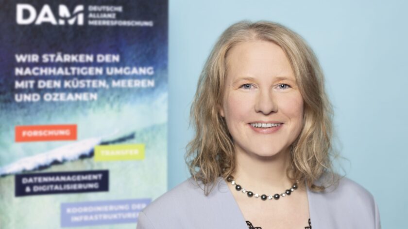 Dr. Swantje Preuschmann vor dem unscharfen DAM-Banner