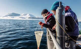 AWI biologist Dr Clara Hoppe (right and, and Dr Klara Wolf are taking algae samples at Kongsfjord, Spitsbergen, which they are going to use for analyzing the chemical composition of the phytoplankton and how much carbon the algae have bound