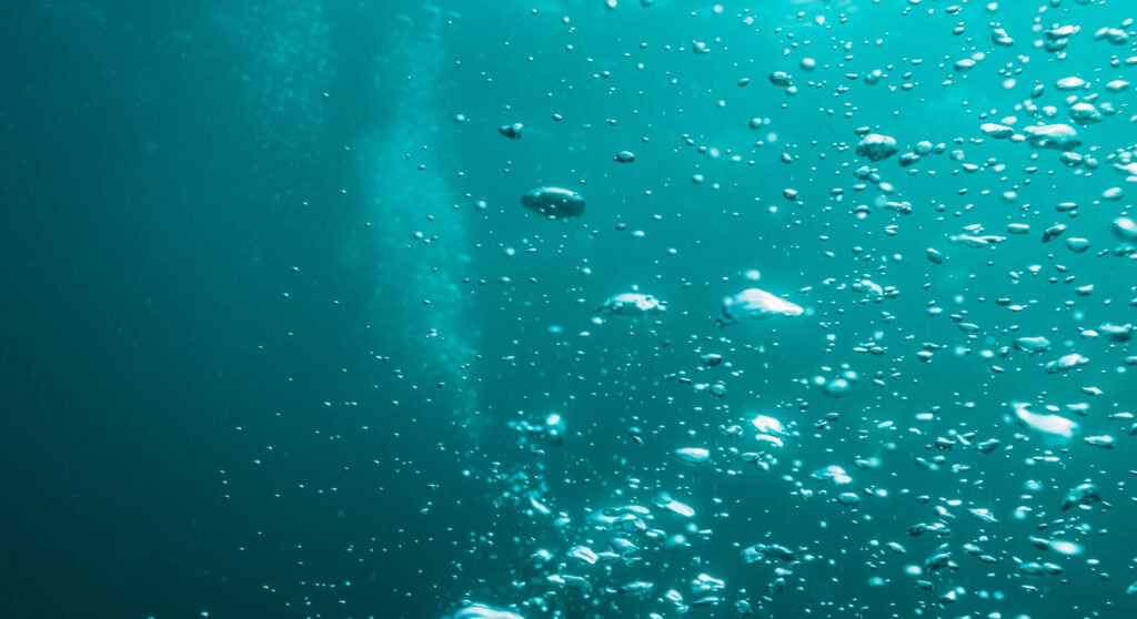 Aufsteigende Blasen unter der Wasseroberfläche