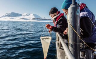 AWI-Biologin Dr. Clara Hoppe (rechts) und Doktorandin Klara Wolf nehmen Algenproben aus dem Kongsfjord, Spitzbergen, Arktis. Phytoplankton-Forschung: Aufnahme von Feldarbeiten der Gruppe um Björn Rost und Clara Hoppe in Ny-Ålesund, Spitzbergen. In diesem Experiment haben die Wissenschaftler natürliche Phytoplankton-Gemeinschaften aus dem Kongsfjord unterschiedlichen Klimawandel-Szenarien (bezüglich Ozeanversauerung und -erwärmung) ausgesetzt und dann verschiedenste Parameter beprobt.