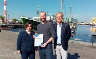 Preisträger Dr. Philipp Grassel (Bildmitte) mit dem Fördervereinsvorsitzenden Jörg Schulz und DSM-Direktorin Prof. Dr. Ruth Schilling im Bremerhavener Fischereihafen. Die Preisverleihung fand zuvor im Rahmen der diesjährigen Fördervereins-Mitgliederversammlung im Forum Fischbahnhof statt.